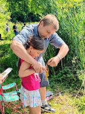 SF1 Scarlett Watson’s father, John, helps her with a fish she caught in the Child &amp; Dad Fishing Derby on Sunday, June 16 at Lake Musconetcong Park in Stanhope. (Photo by Maria Kovic)