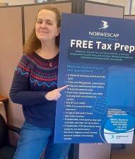 Peggy Curtis of Norwescap holds a poster about the Volunteer Income Tax Assistants program. (Photo provided)