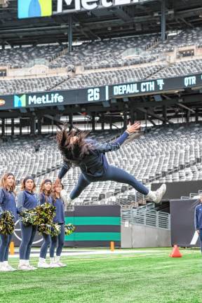 Pope John senior Marissa Marston does a stunt along the Lions sideline during a second-half timeout.