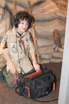 A Cub Scout from Den 2 operates audio equipment during the production of the den's three-minute movie.