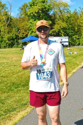 Tim Carrollo, 31, of Sussex places second with a time of 23:30.72.