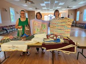 Tranquility United Methodist Church members, from left, Barbara Morgan, Barbara Gardiner and Charlene Cook stand behind homemade items to be auctioned Saturday.