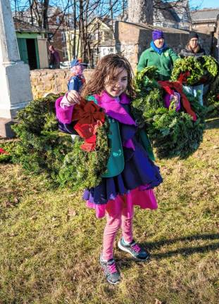 Katrina Carson holds wreaths on both arms. (Photo by Nancy Madacsi)