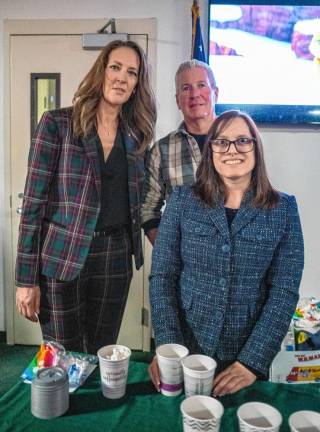 Dave and Kimberly Williams and Paige Loughran hand out hot cocoa.