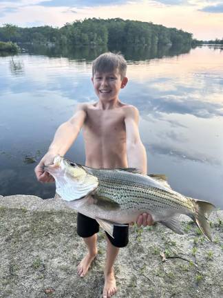 Mikey Holland, 11, of Byram caught this hybrid striped bass in a township lake on Sunday, July 23. It weighed about 13.5 pounds. (Photo provided)