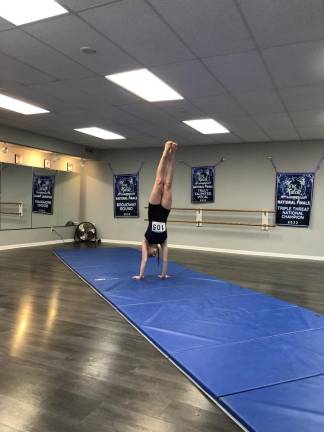 A girl does a handstand to show her athletic ability.