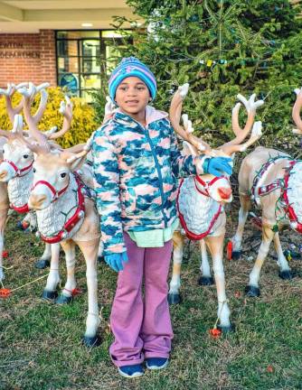 Kristianna Christ poses with reindeer set up outside the Newton municipal building.