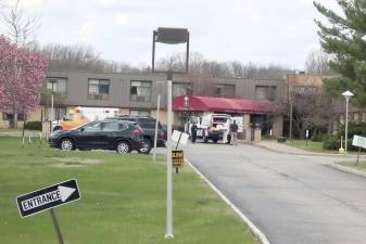 Ambulance crews are parked outside Andover Subacute and Rehabilitation Center in Andover, N.J., on Thursday April 16, 2020. Police responding to an anonymous tip found more than a dozen bodies Sunday and Monday at the nursing home in northwestern New Jersey, according to news reports. (AP Photo/Ted Shaffrey)