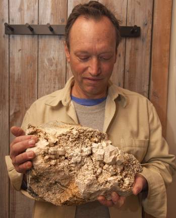 Glenn Rhein displaying one of his mineral rock collection at his home in Amity