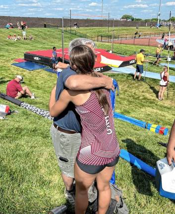 SS2 Coach Jake Mull embraces Sierra Strasser. who set a school record in pole vault.