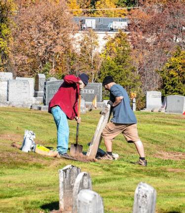 RW2 Jack and Bill Wyman straighten the headstone at the grave of their ancestor Amos Dustin.