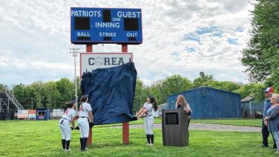 Lenape Valley Regional High School softball team captains unveil the sign for Corea Field on May 9.