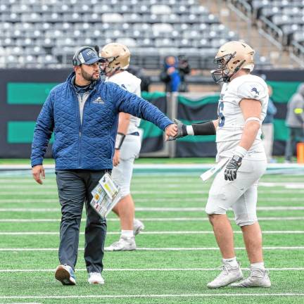 Pope John head football coach Dom Gaston reaches out to one of his linemen after the Lions’ loss to DePaul.