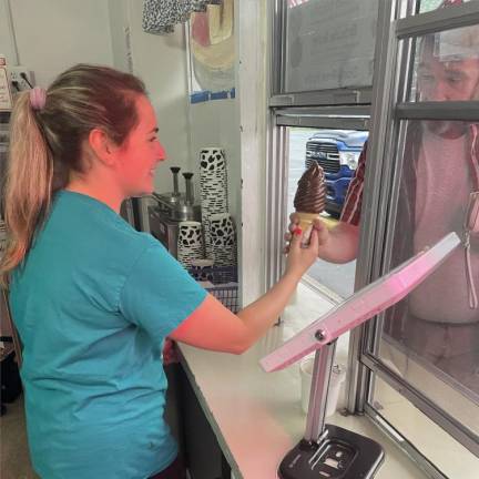 Jolie hands ice cream to a customer.