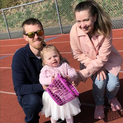 Sadie Shalinsky, age 1 1/2, is ready for her first Easter Egg Hunt on Saturday in Newton. With her are her parents, Greg and Kelsey of Newton.