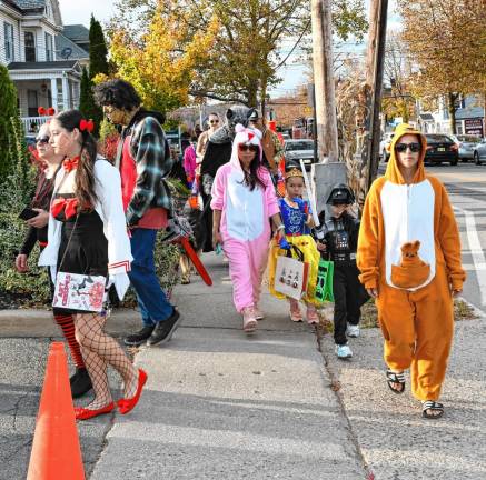 Costumed children and parents take part in the Halloween Parade in Newton.