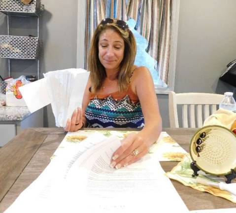 Kristine Cerza goes through letters from fellow Cranberry Lake residents at her home on Strawberry Point in Cranberry Lake on Thursday, August 30, 2018. Cerza and her husband Mark are spearheading the efforts to oppose mandatory membership in the Cranberry Lake Community Club. Photos by Mandy Coriston