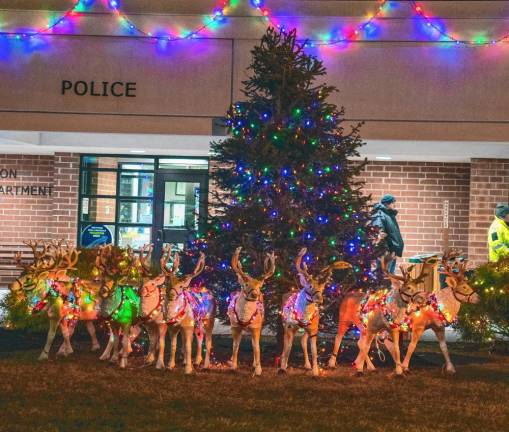 The Christmas tree is lit in front of the Newton municipal building.