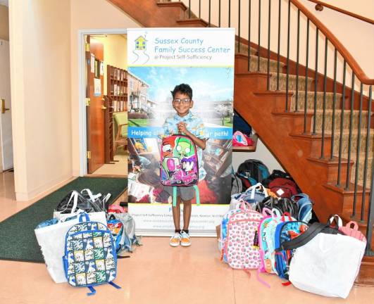 Chase Camarena, 7, poses with backpacks he filled with donated school supplies for students who need them. (Photos by Maria Kovic)