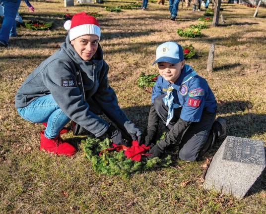 Reina and John Loconte place a wreath Saturday, Dec. 14 at the Old Newton Burial Ground. (Photo by Nancy Madacsi)