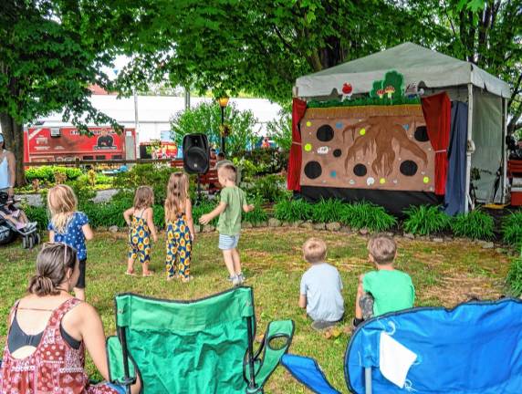 <b>Children take part in a puppet show at the fair. (Photo by Nancy Madacsi)</b>