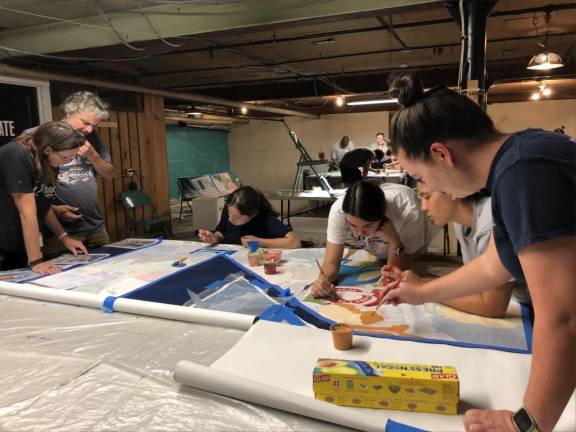 From left are artist Caren Olmsted and her assistant and Katelyn McDade, Natalie Fung, Jennifer Ellsworth and Lauren Hennighan, who assisted with the painting.