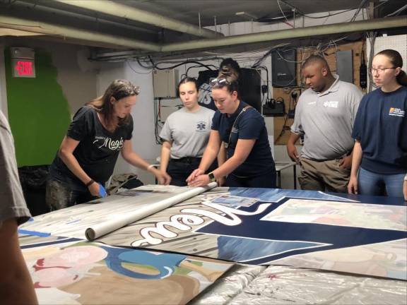 From left are artist Caren Olmsted, who designed the mural, and Kelly Ellsworth, Lauren Hennighan, Caiden Schabacker and Hannah Gallagher, all members of the Newton First Aid Squad who helped with the mural painting Sunday, July 30. (Photos by Kathy Shwiff)