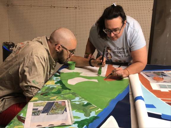 Chris Jones and his mother, Denise Kelly-Jones of Green Township, work on the mural.