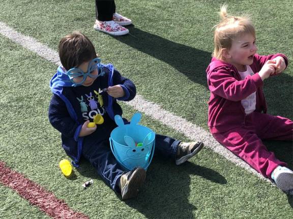 Children break open the plastic eggs to see what’s inside.