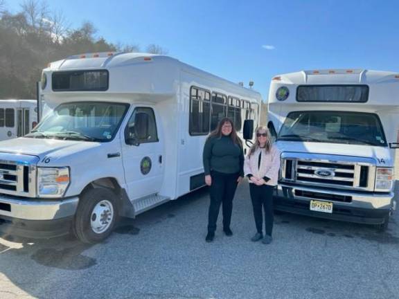 Sussex County Commissioner Jill Space, left, and Christine Florio, administrator of the county Department of Health and Human Services, stand by the new buses. (Photo provided)