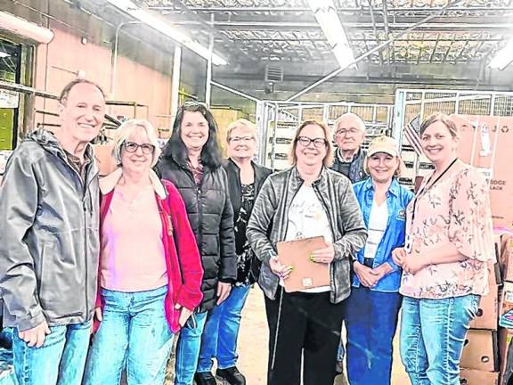 Rotary Club members and friends pose with the food pantry manager in Newton.