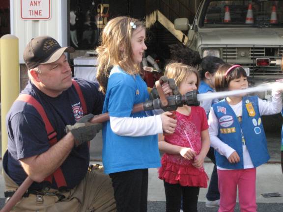 Photo Provided Members of Girl Scout Troop 5624 operate the fire house with the help of a Fredon fire fighter.