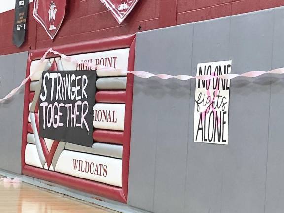 Signs with encouraging messages are posted on the gym walls.