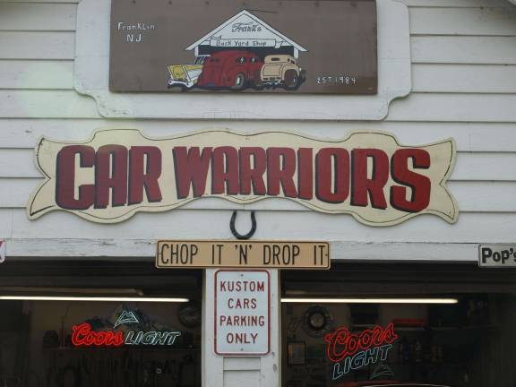 Car Warriors sign on Frank Bedacht's workshop in Franklin Photos by John Church