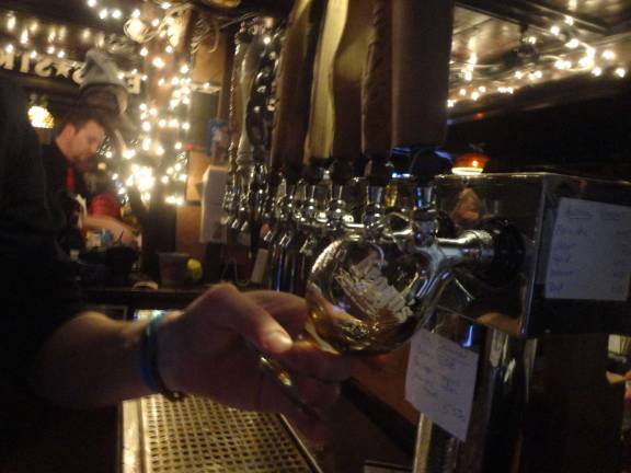 Photos by Scott Baker Bartender Julian Huarte, of Newton, pours a 15th anniversary Russian imperial stout into a commemorative glass.