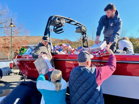 Volunteers unload toys filling a Nautique boat Tuesday, Dec. 12 at Project Self-Sufficiency in Newton. (Photo courtesy of Project Self-Sufficiency)