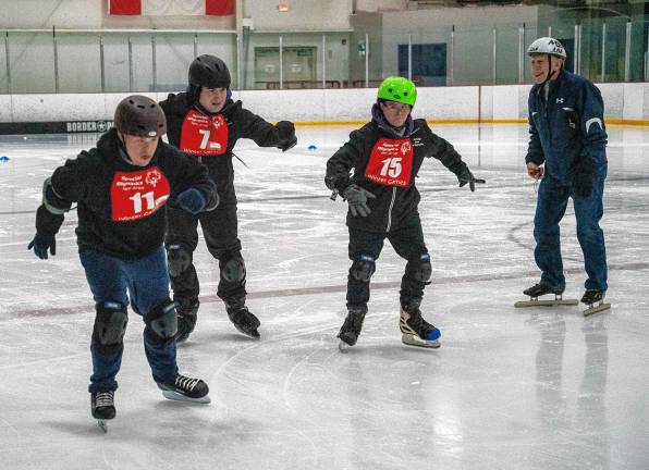 <b>Volunteer Al Harding watches speed skaters, from left, Joseph Pilchuk, Salvatore Luppino and James Smith. (Photo by Nancy Madacsi)</b>