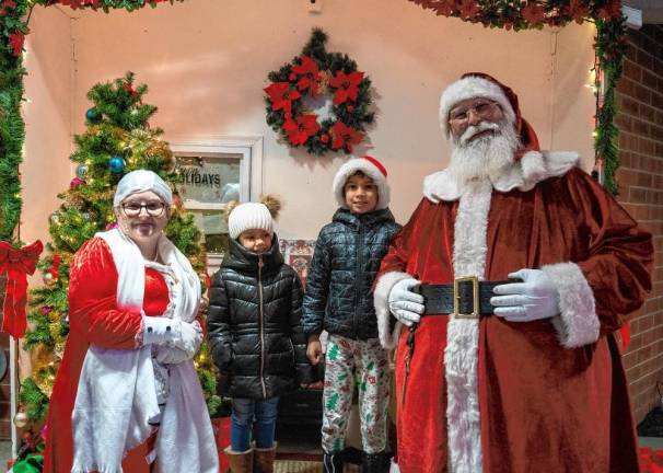 Leanna and Nathaniel Vargas pose with Santa and Mrs. Claus.