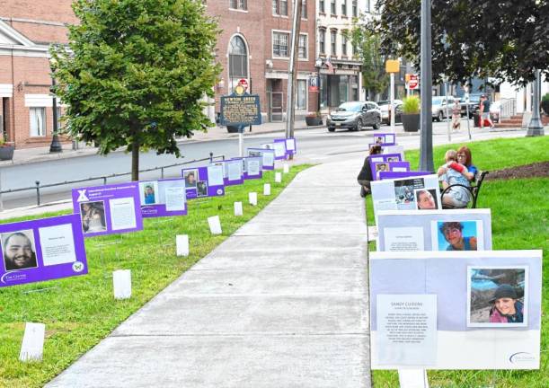 Photos of people lost to overdoses line the walkway on the Newton Green on Wednesday, Aug. 28 to mark International Overdose Awareness Day. (Photos by Maria Kovic)