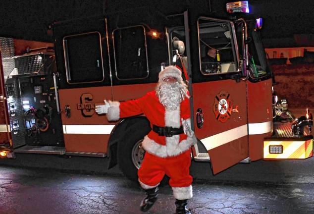 Santa arrives on a firetruck.