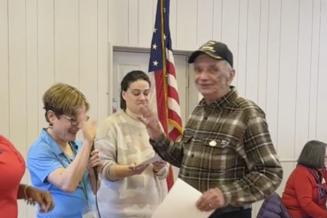 Jacqui Gieske, left, high fives John Harrigan, an Army veteran. At center is Andrea Capita.