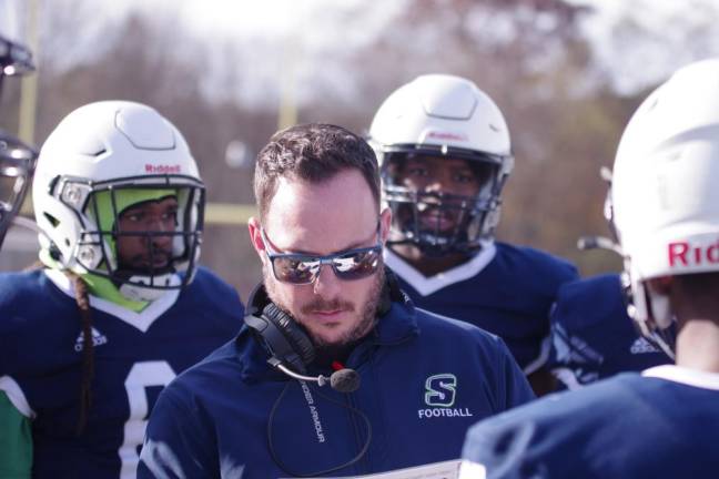 Sussex Skylanders head football coach James Robertson discusses strategy with players.