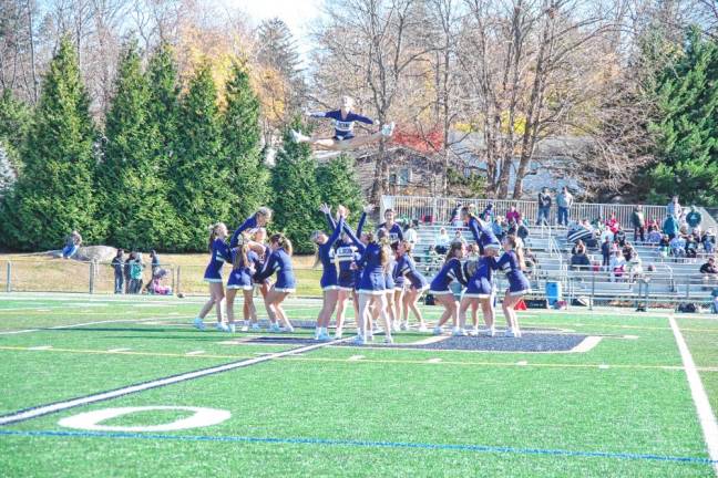 <b>A cheerleader is airborne as the Pope John XXIII Regional High School team perform during halftime. (Photo by George Leroy Hunter)</b>