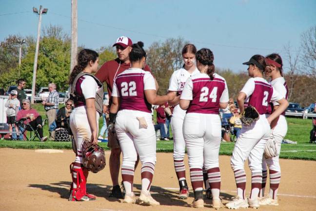 The Newton Braves and their coach Paul Filan meet on the mound.