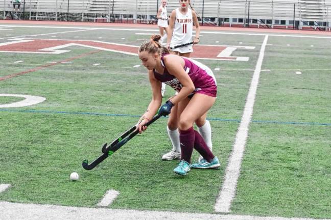 While reaching for the ball, Newton's Emma Trout stays ahead of her Voorhees opponent in the second period.