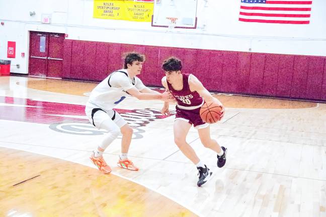 Newton's Maxwell Maslowski drives with the ball while covered by Kittatinny's Michael Strong.