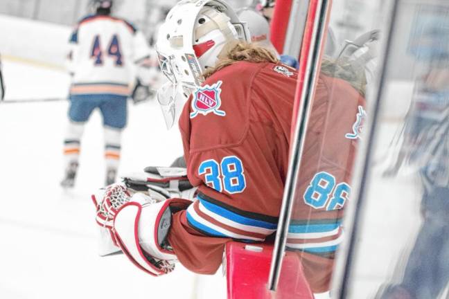 Newton-Lenape Valley goalie Patrick Boden leans over the sideboard as he looks at the action on the ice.