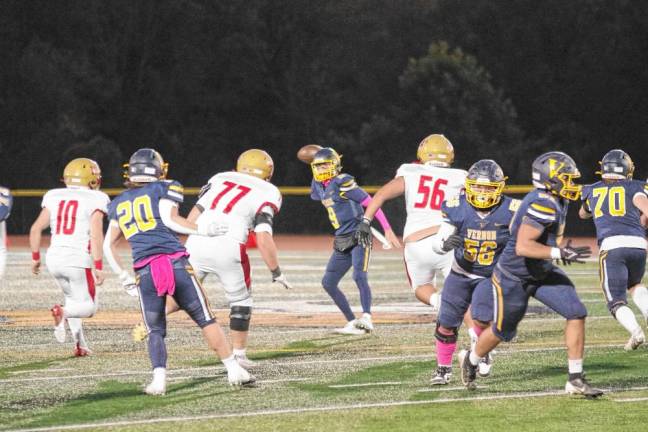 <b>Vernon quarterback Aden Karwoski is about to throw the ball as Mount Olive defenders approach.</b>