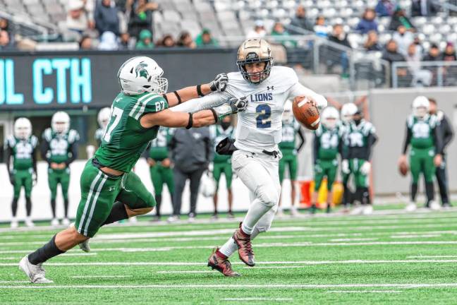 Pope John’s quarterback Luke Irwin tries to fight off the tackle attempt of DePaul’s Ethan Lilley in the first half.