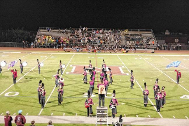 <b>The Newton High School Marching Band and Color Guard perform during halftime.</b>